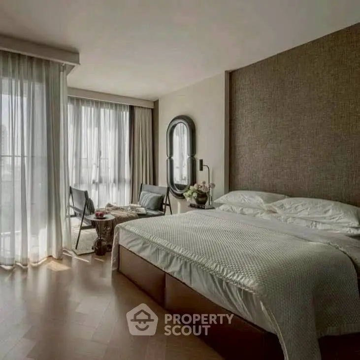 Luxurious bedroom with elegant decor and large windows offering natural light.