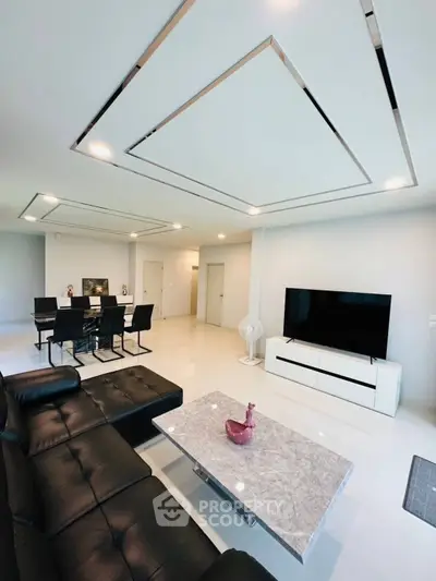 Modern living room with sleek black leather sofa and marble coffee table
