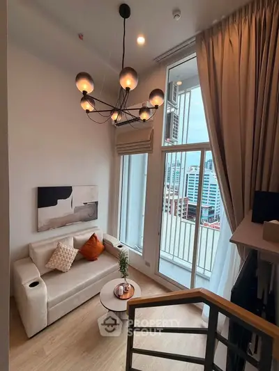 Modern living room with stylish chandelier and city view balcony