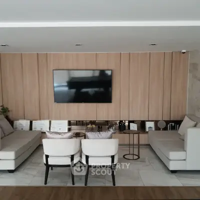 Elegant living room with modern furniture and wall-mounted TV, perfect for relaxation and entertainment.