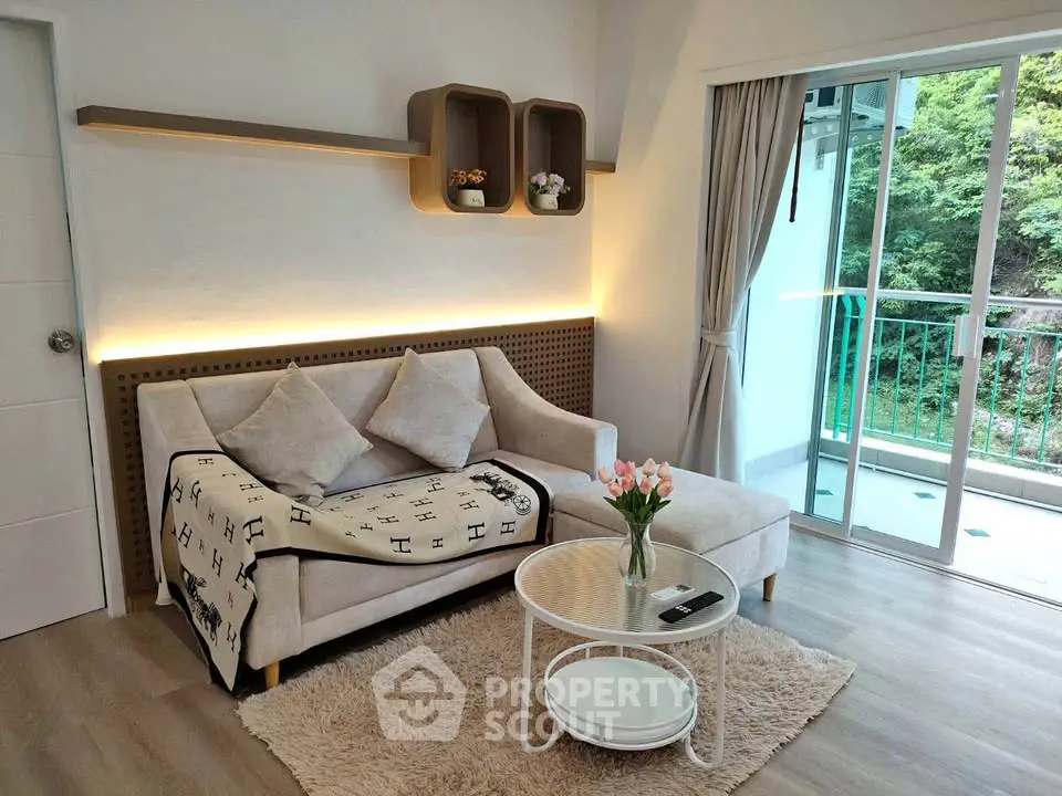 Charming living room with cozy sofa, elegant decor, and balcony view, perfect for relaxation and comfort.