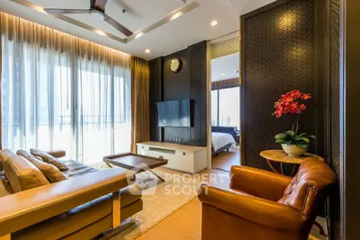 Luxurious living room with leather seating, modern decor, and large windows offering natural light.