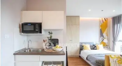 Modern studio apartment with compact kitchen and cozy bedroom area.