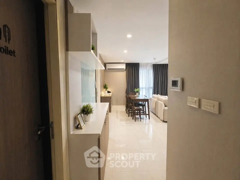 Modern open-layout living room with sleek design and natural light, featuring dining area and cozy seating.