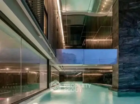 Luxurious indoor swimming pool with modern design and ambient lighting in a high-end residential building.