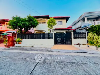 Charming suburban house with red roof and lush garden in a peaceful neighborhood.