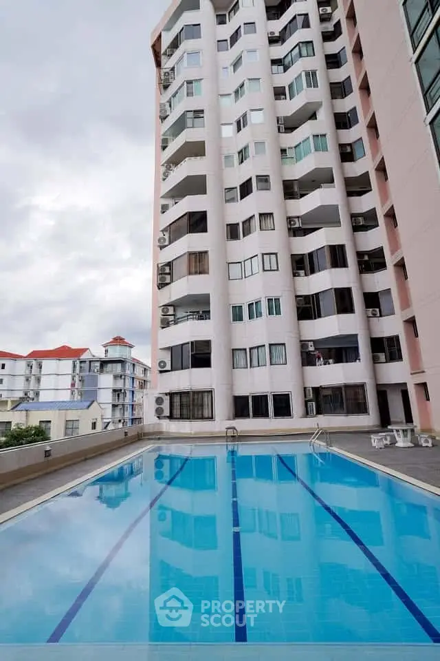 Stunning apartment building with a sparkling outdoor pool, perfect for relaxation and leisure.