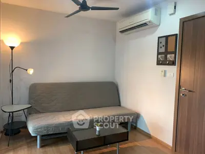 Cozy living room with modern sofa, air conditioning, and stylish lighting.