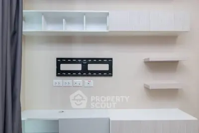 Modern minimalist living room with wall-mounted shelves and TV bracket.