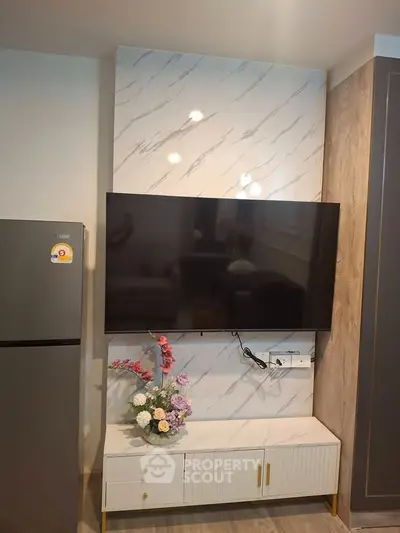 Modern living room with sleek TV setup and elegant marble wall design.
