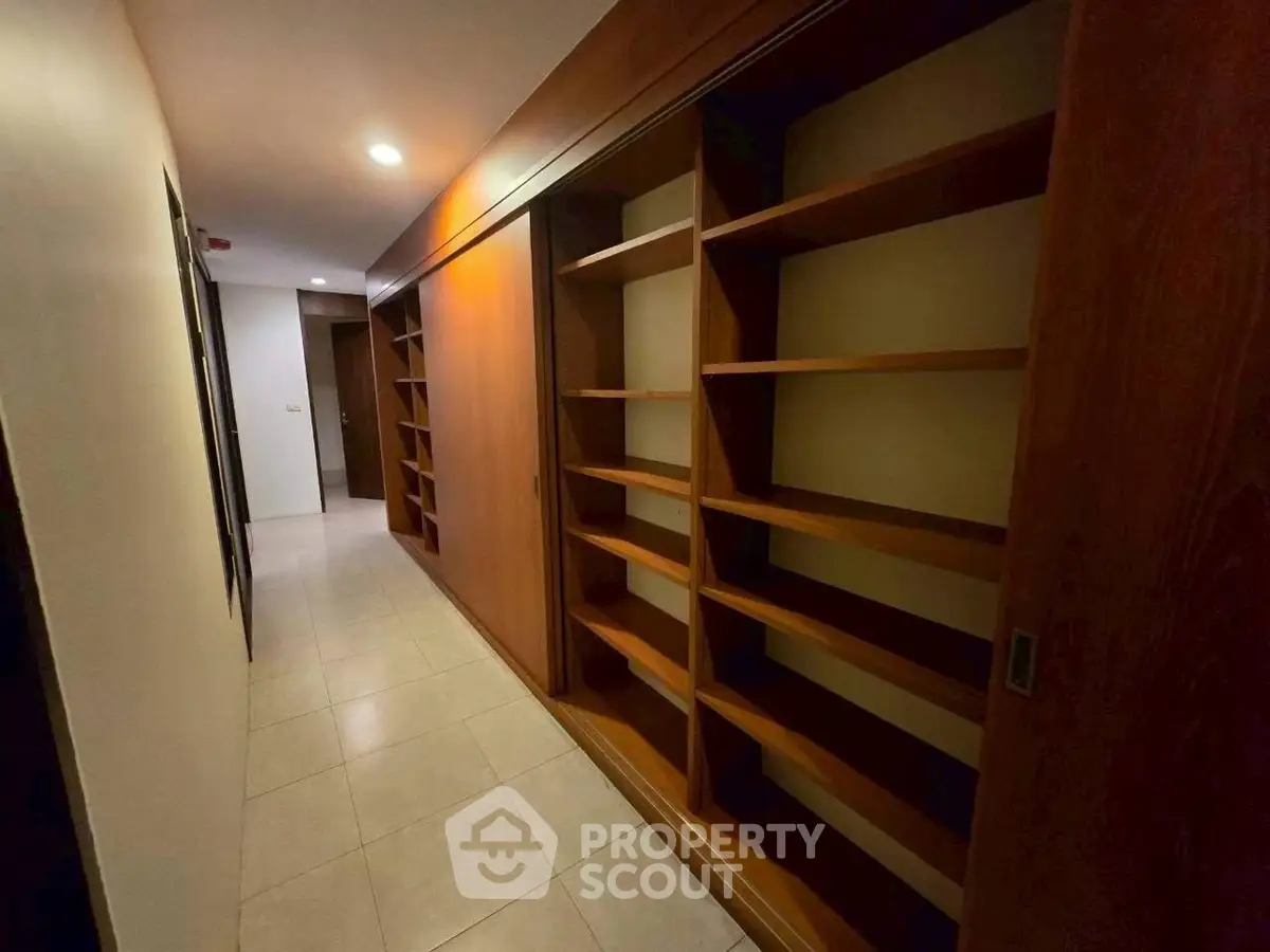 Spacious hallway with built-in wooden shelving in modern home