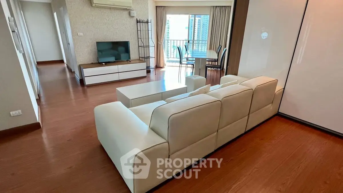Spacious living room with modern furniture and balcony view in a stylish apartment.