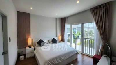Spacious bedroom with large windows and modern decor in a stylish home.