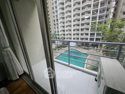 Modern apartment balcony with pool view in urban high-rise building