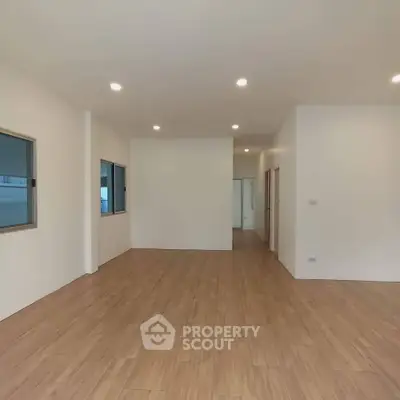 Spacious modern interior with wooden flooring and recessed lighting, ideal for versatile living space.