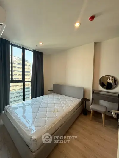 Modern bedroom with large window and stylish furniture in urban apartment