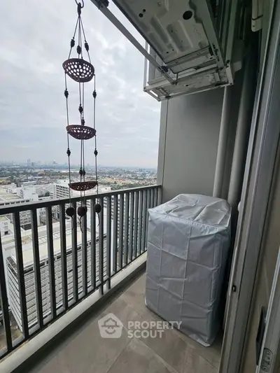 High-rise balcony with city view and covered appliance, ideal for urban living.