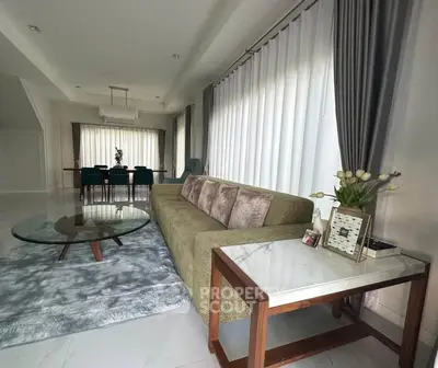 Elegant living room with modern furniture and large windows, perfect for stylish living.