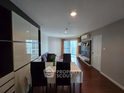 Modern living room with dining area and city view, featuring sleek furniture and stylish decor.