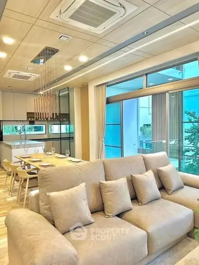 Modern living room with cozy beige sofa and open kitchen layout