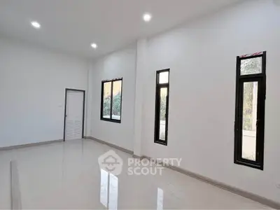 Spacious modern living room with large windows and sleek tile flooring