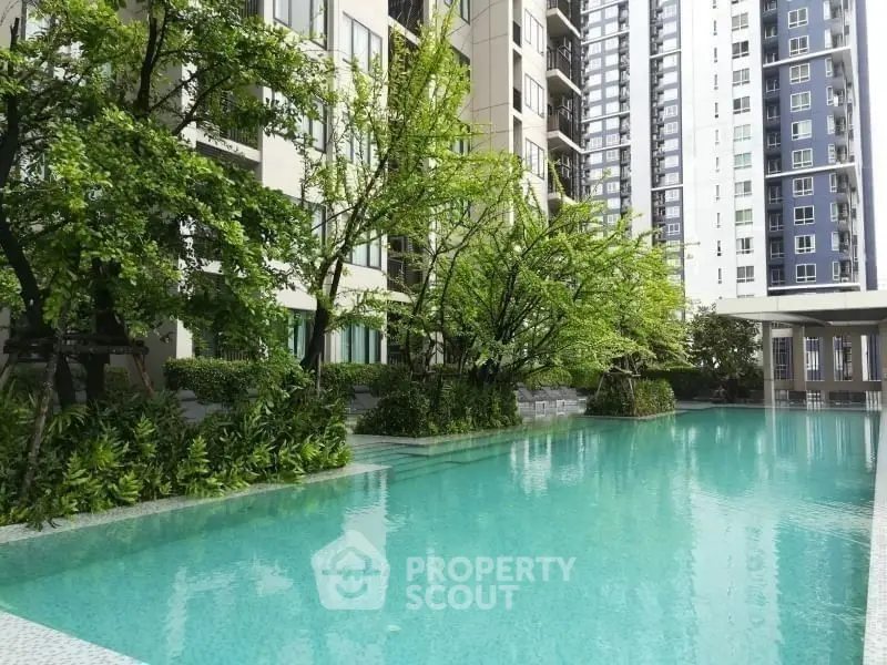 Luxurious apartment complex with a stunning outdoor pool and lush greenery.