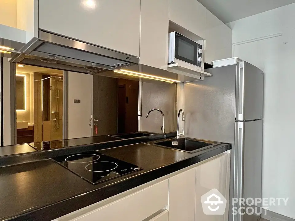 Modern kitchen with sleek appliances and glossy cabinetry in a stylish apartment.