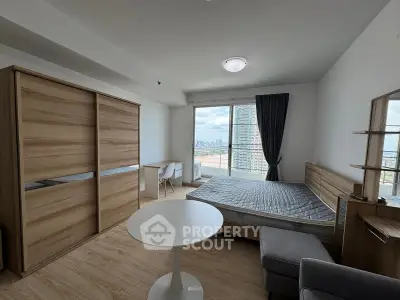 Modern bedroom with city view, featuring wooden furniture and natural light.