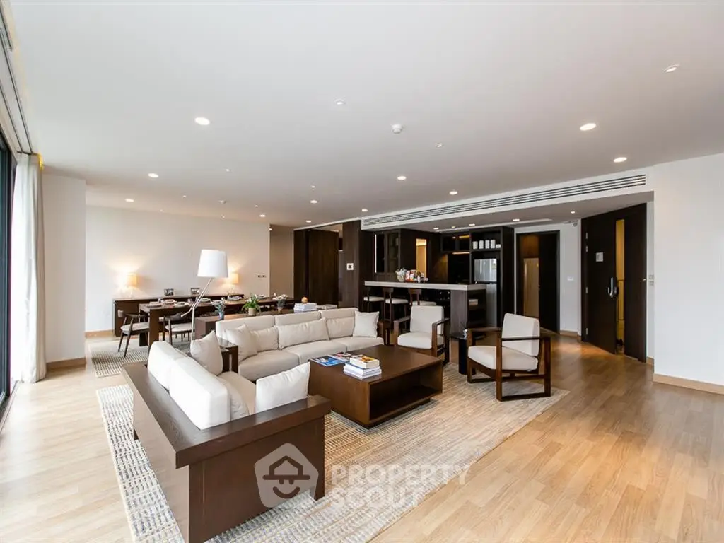 Spacious modern living room with open kitchen and elegant wooden flooring.