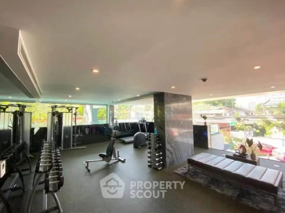 Spacious modern gym with state-of-the-art equipment and panoramic city views.
