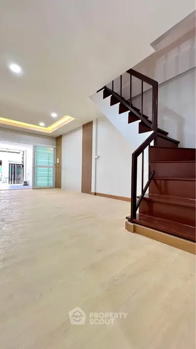 Spacious modern living room with sleek staircase and elegant lighting