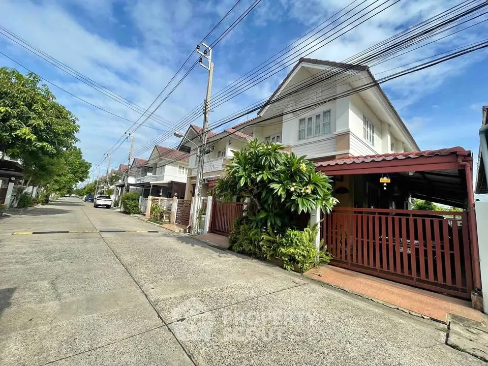 Charming suburban house with lush greenery and spacious driveway in a peaceful neighborhood.