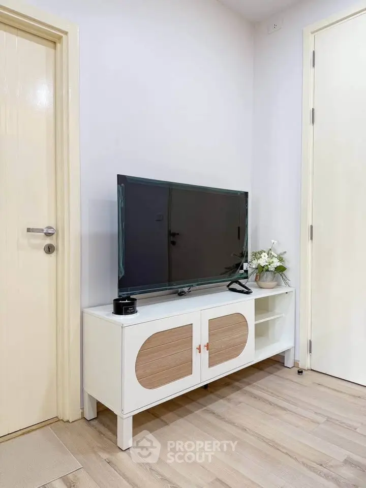 Modern living room with sleek TV stand and flat-screen TV, showcasing minimalist design and elegant decor.