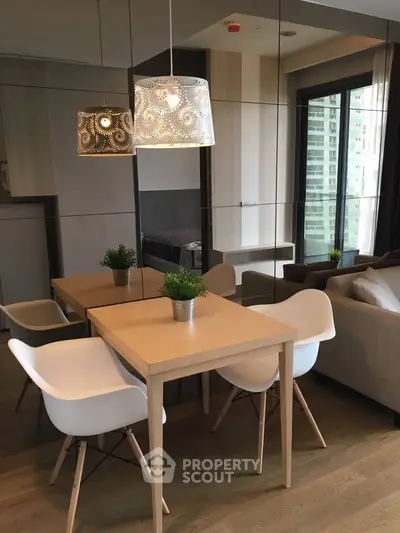 Modern dining area with stylish chairs and elegant lighting in a cozy apartment setting.