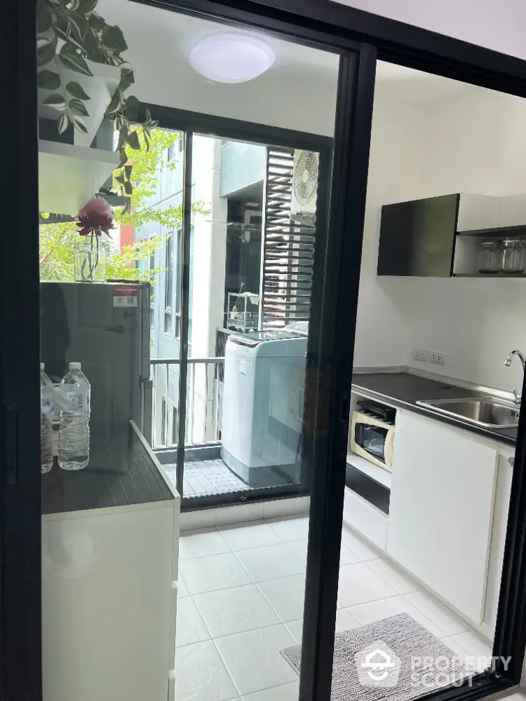 Modern kitchen with balcony view and sleek appliances