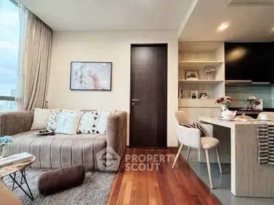 Modern living room with cozy seating and open kitchen layout in stylish apartment.