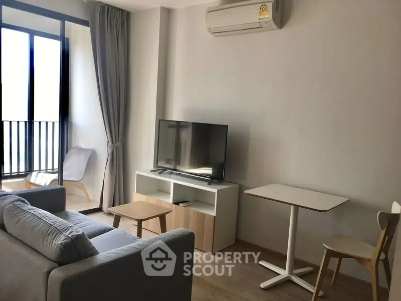 Modern living room with sleek furniture and balcony access in a stylish apartment.