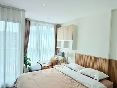Bright and cozy bedroom with modern decor and large windows in a stylish apartment.