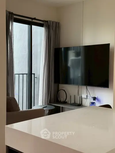 Modern living room with wall-mounted TV and balcony view