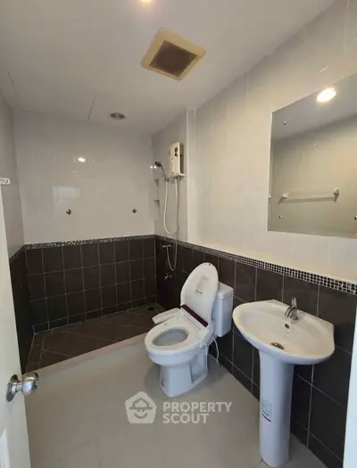 Modern bathroom with sleek design, featuring a shower area and contemporary fixtures.