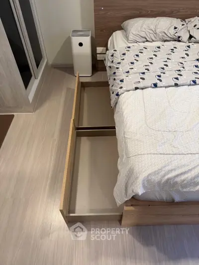 Modern bedroom with under-bed storage and air purifier, showcasing sleek design and functionality.