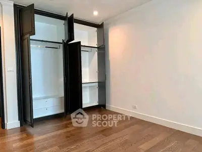 Spacious empty room with wooden floor and built-in wardrobe