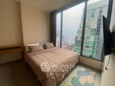 Modern bedroom with large window offering stunning city view in high-rise apartment.