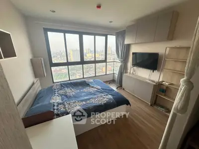 Modern bedroom with large window offering stunning city view, featuring sleek furniture and cozy decor.