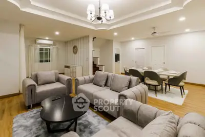 Spacious modern living room with elegant dining area and plush gray sofas