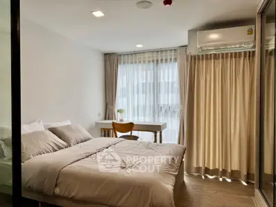 Cozy modern bedroom with large window and natural light