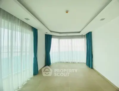 Spacious empty room with large windows and elegant curtains