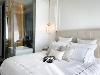 Luxurious bedroom with elegant decor and modern lighting, featuring a stylish glass partition and plush bedding.
