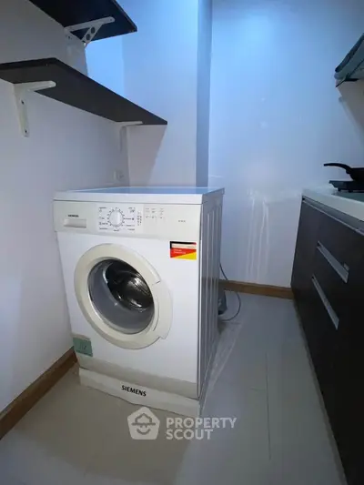 Modern laundry area with Siemens washing machine and sleek cabinetry.