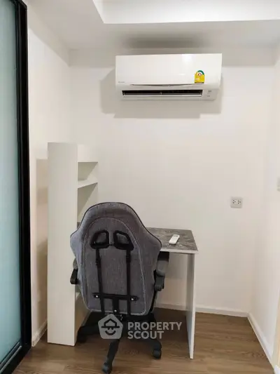 Compact study room with modern desk, chair, and air conditioning unit.